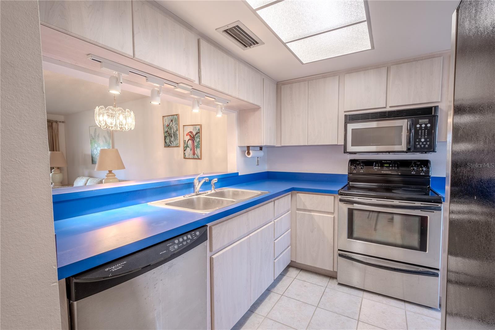 The kitchen features ceramic tile floor, solid surface counters and plenty of cabinet space.