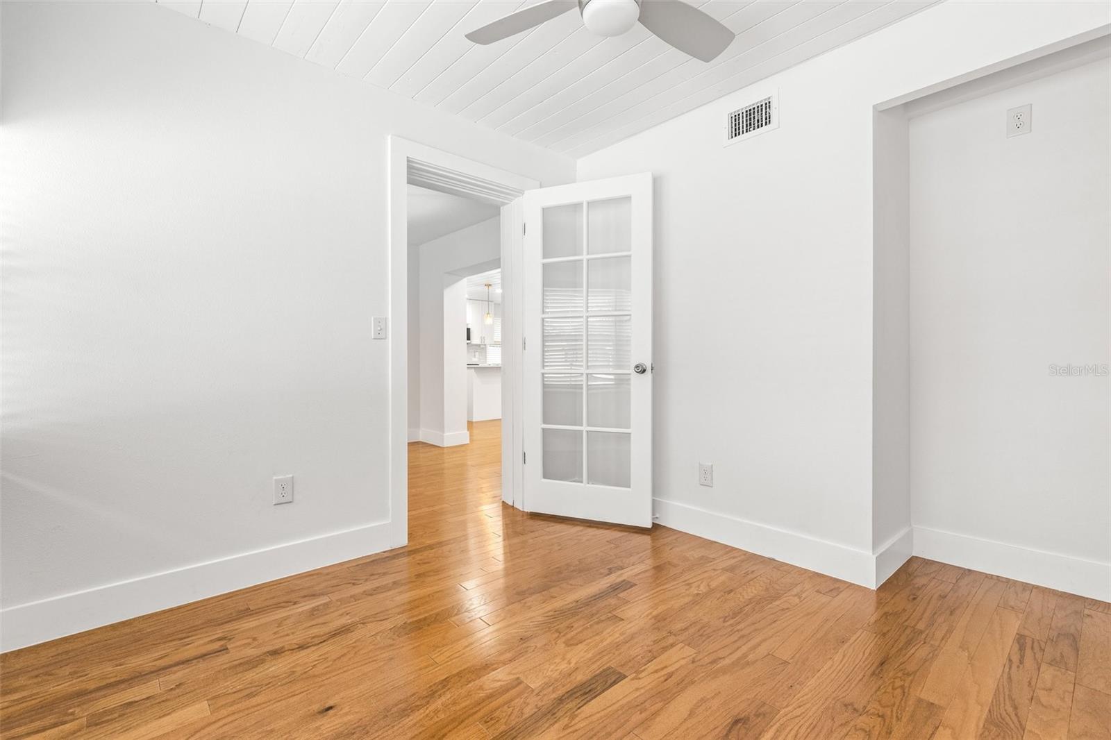 Office/den with niche area glass door from dining area