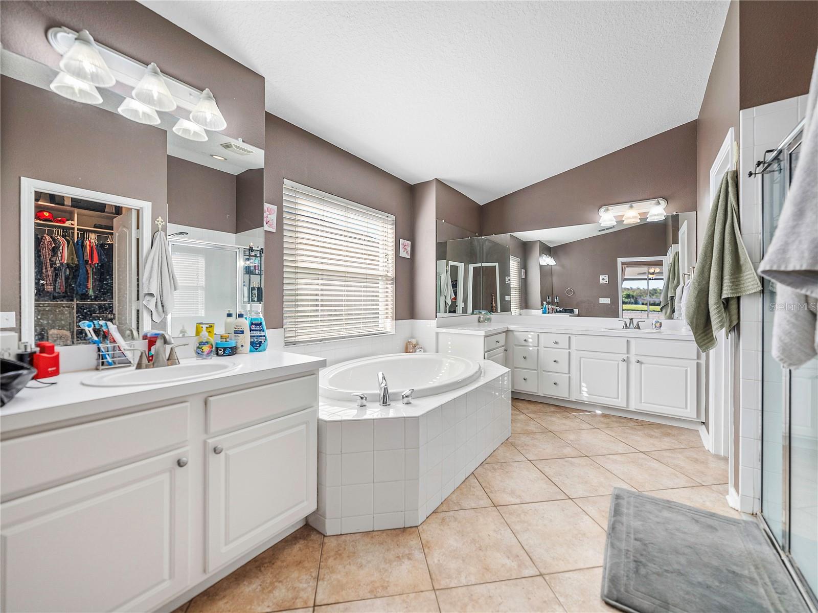 Primary bathroom features dual vanities, soaker tub and separate shower