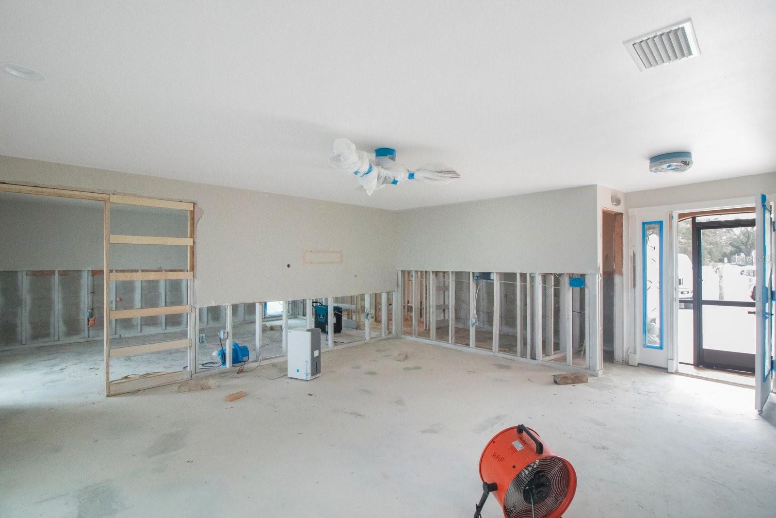 Living room view to the front entry way and the primary bedroom to the left.