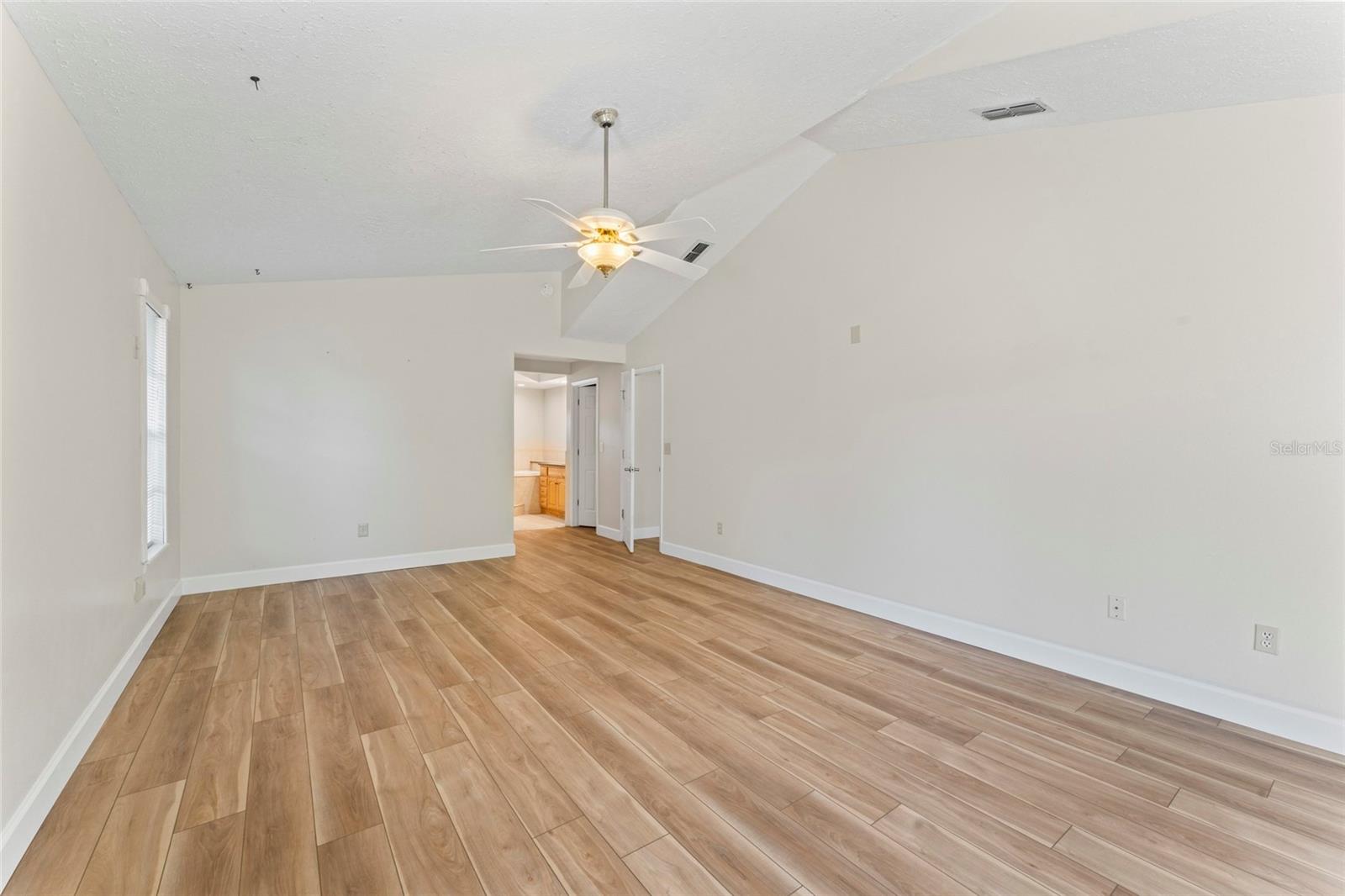 primary bedroom suite view to bath and dual walk in closet space