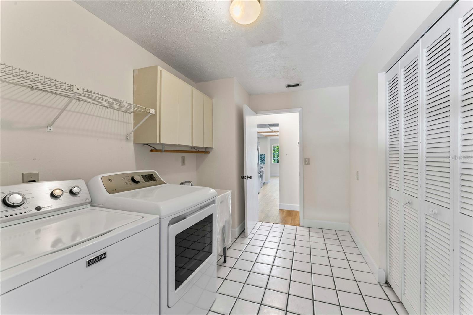 big laundry room with cabinets and large storage closet