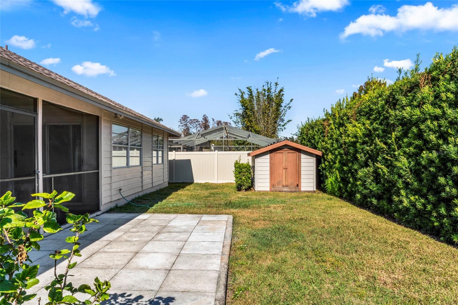 view of totally fenced back yard with added grill or entertainment patio