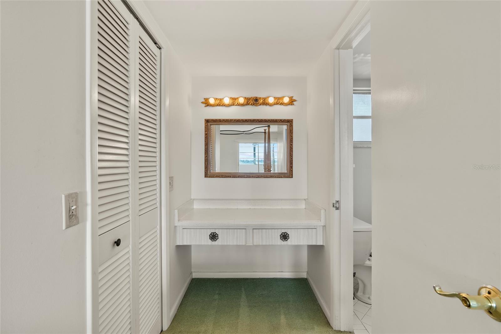 Vanity between the primary bathroom (right) and walk-in closet (left)