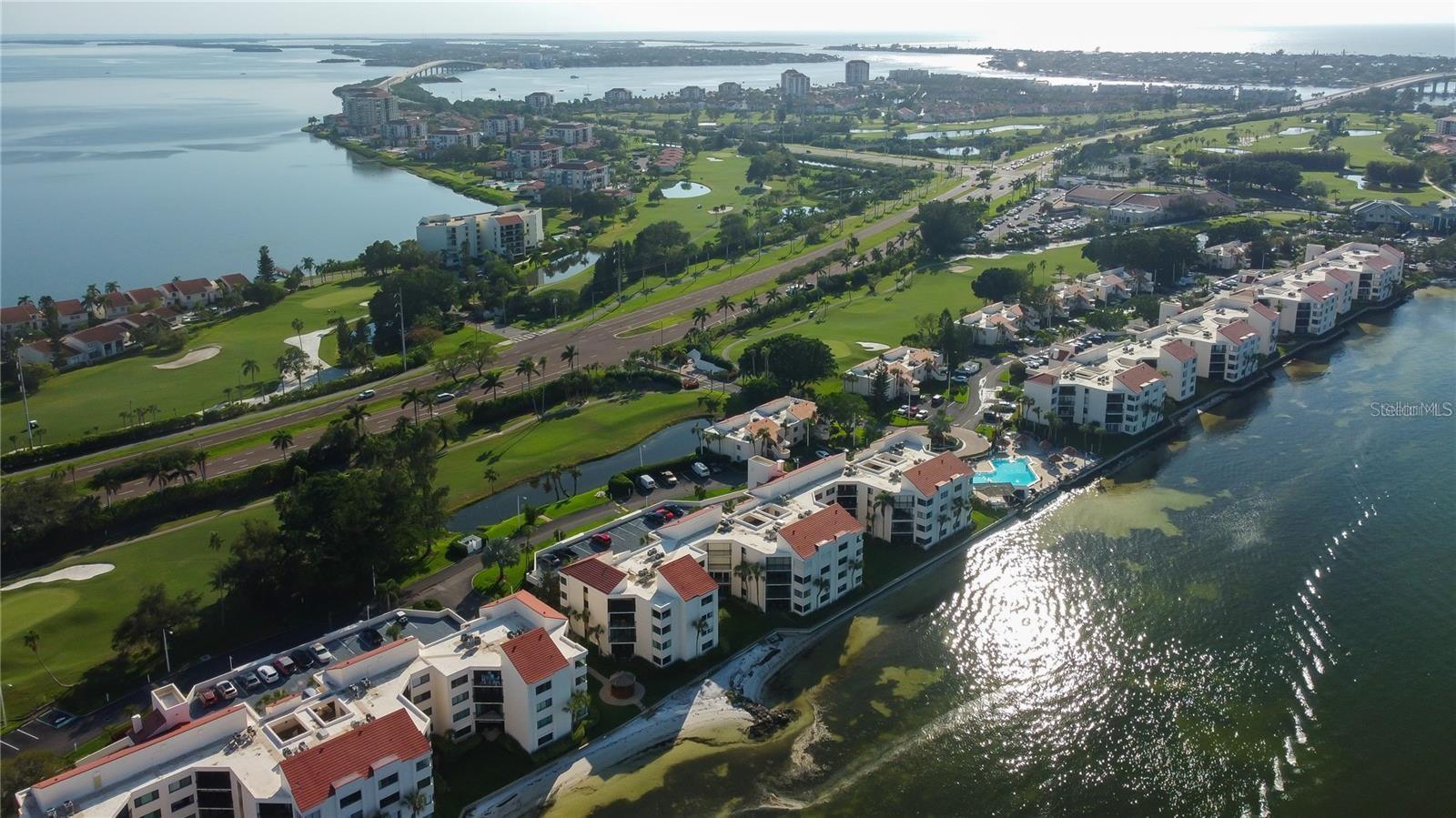 Aerial view of golf course and water surrounding the La Puerta complex