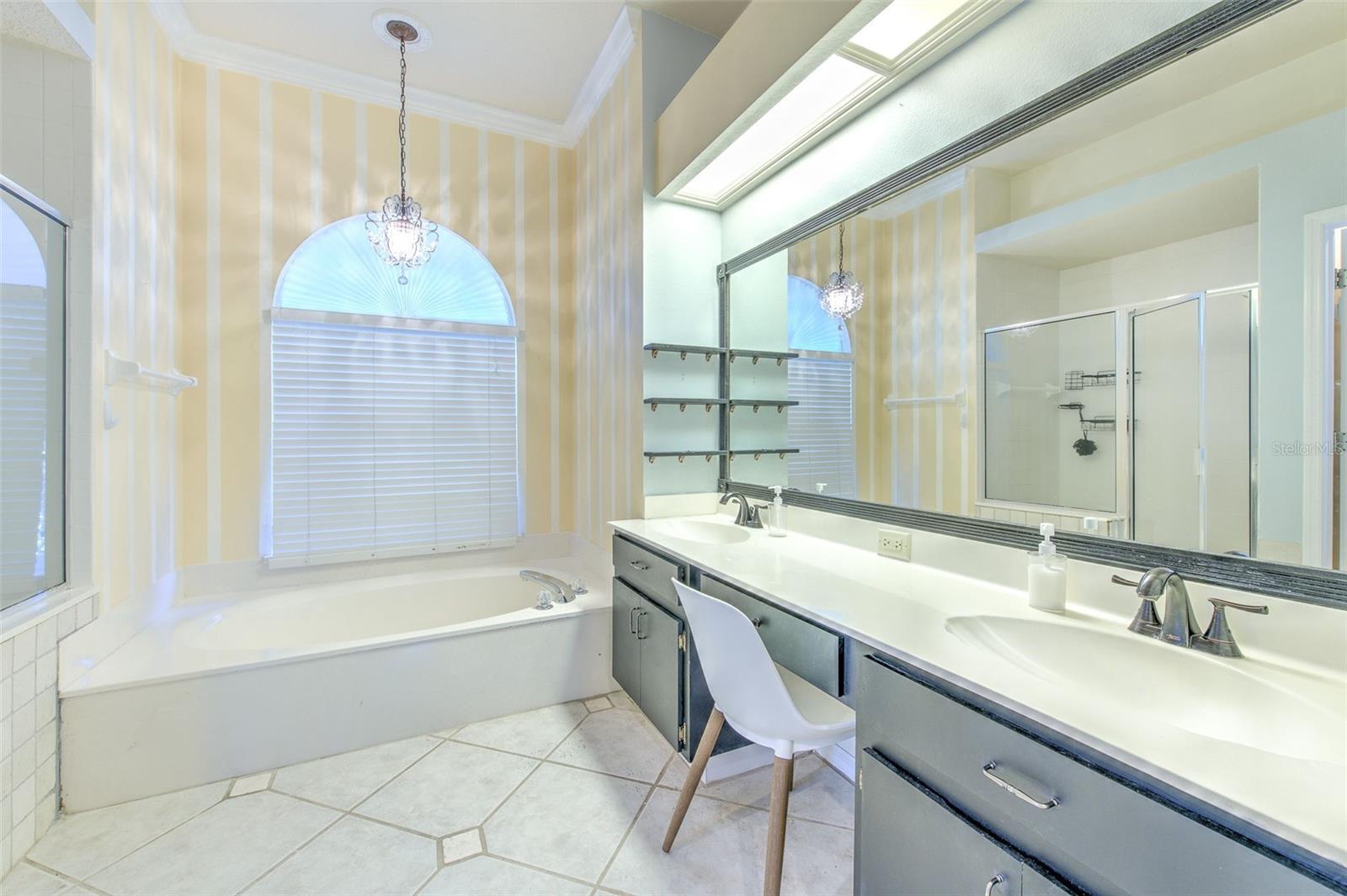 Primary Bathroom with double sinks, soaking tub, and separate shower