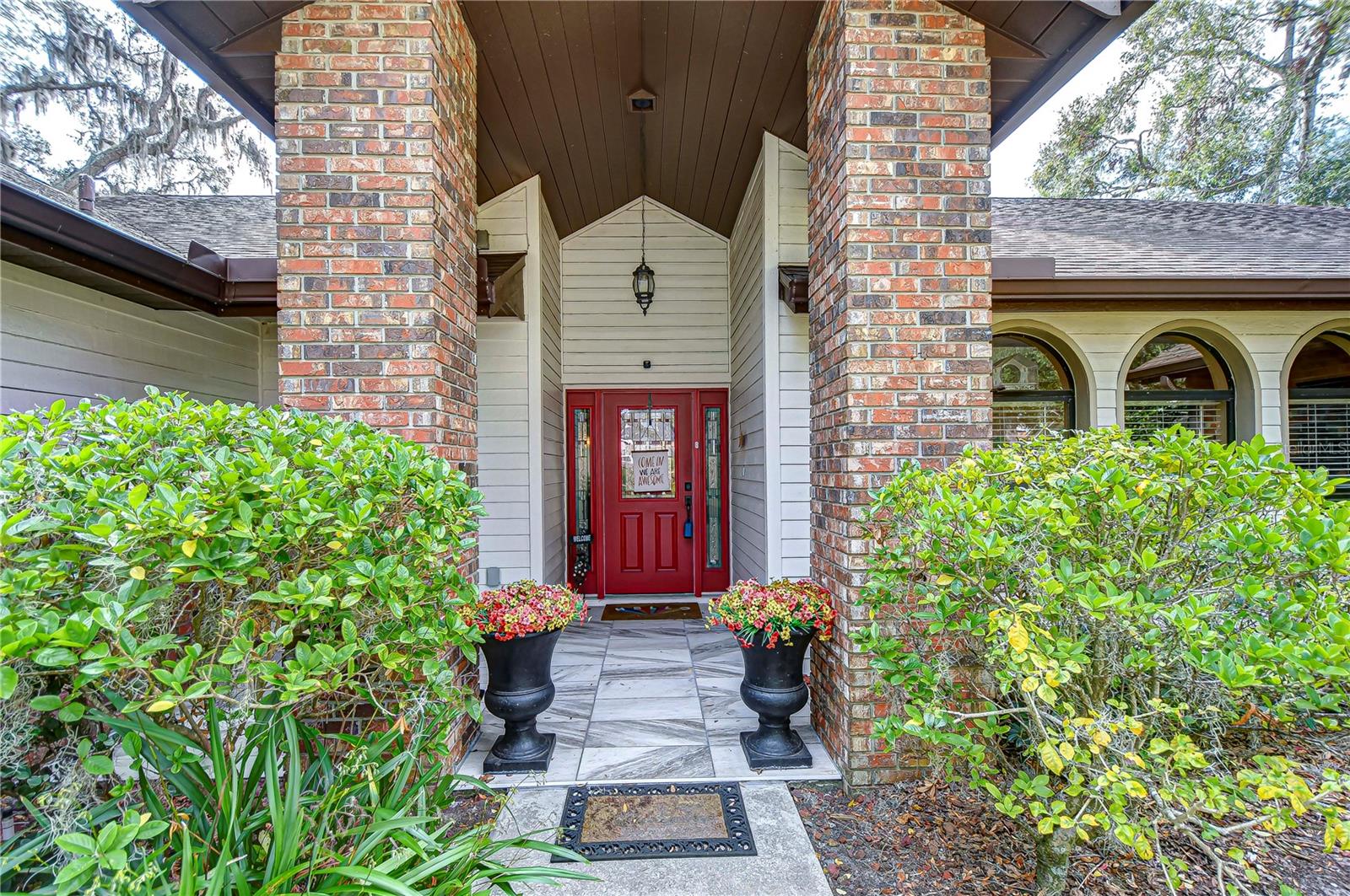 Massive front door entrance with stacked brick pillars and tiled porch!