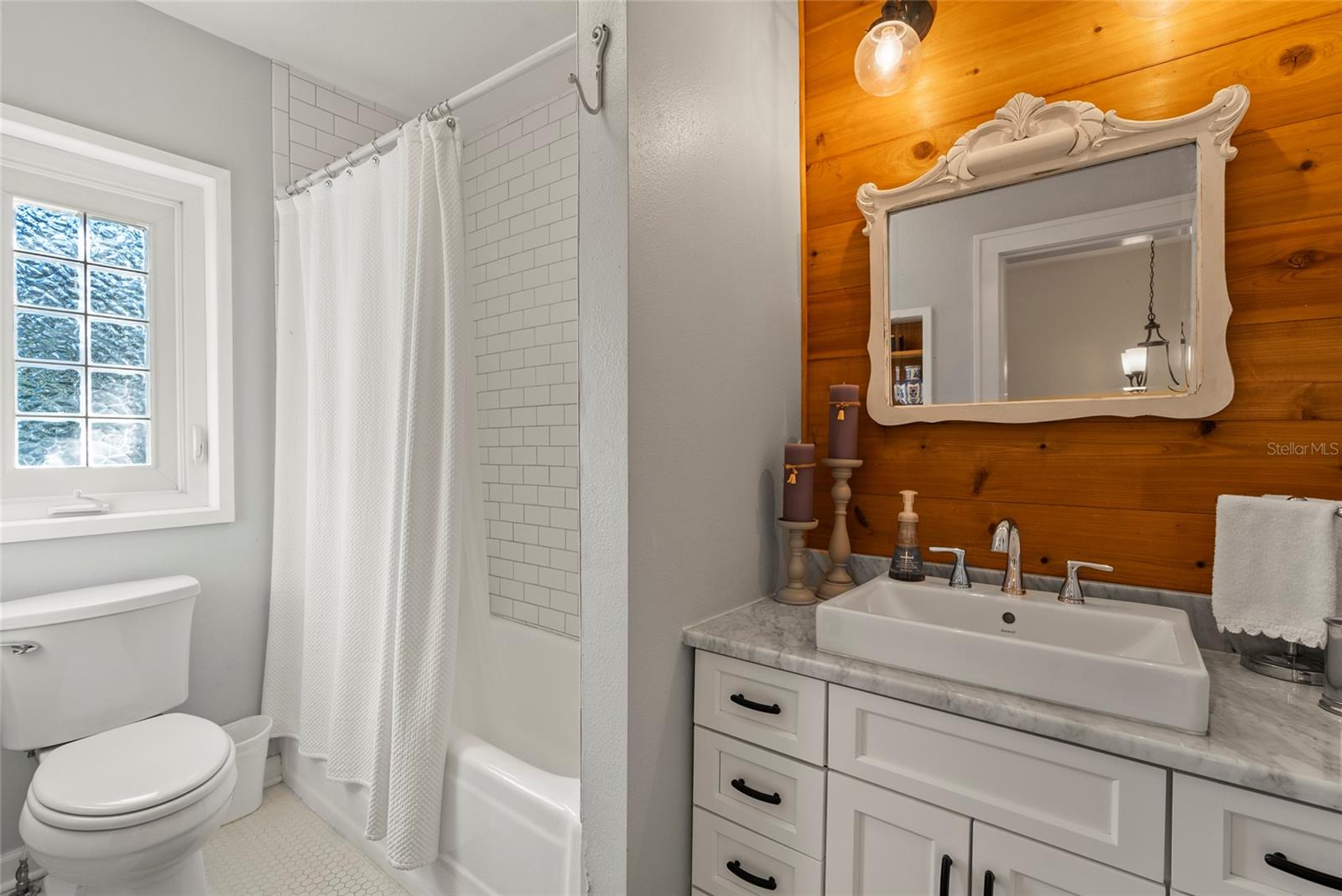 The guest bedroom upstairs features a tub/shower combo, vanity and built-in shelving.