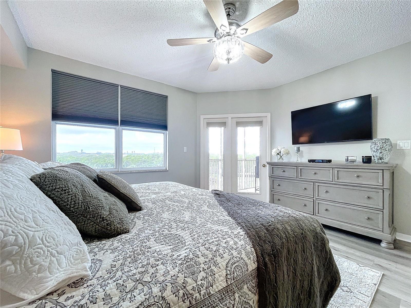 The Primary bedroom offers its own balcony access through French doors as well as plenty of natural lighting.