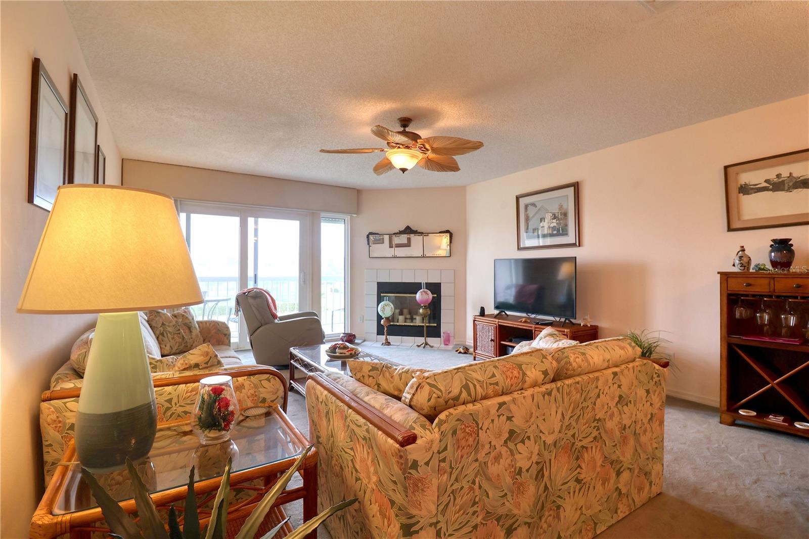 Living room with fireplace and balcony overlooking the tennis courts