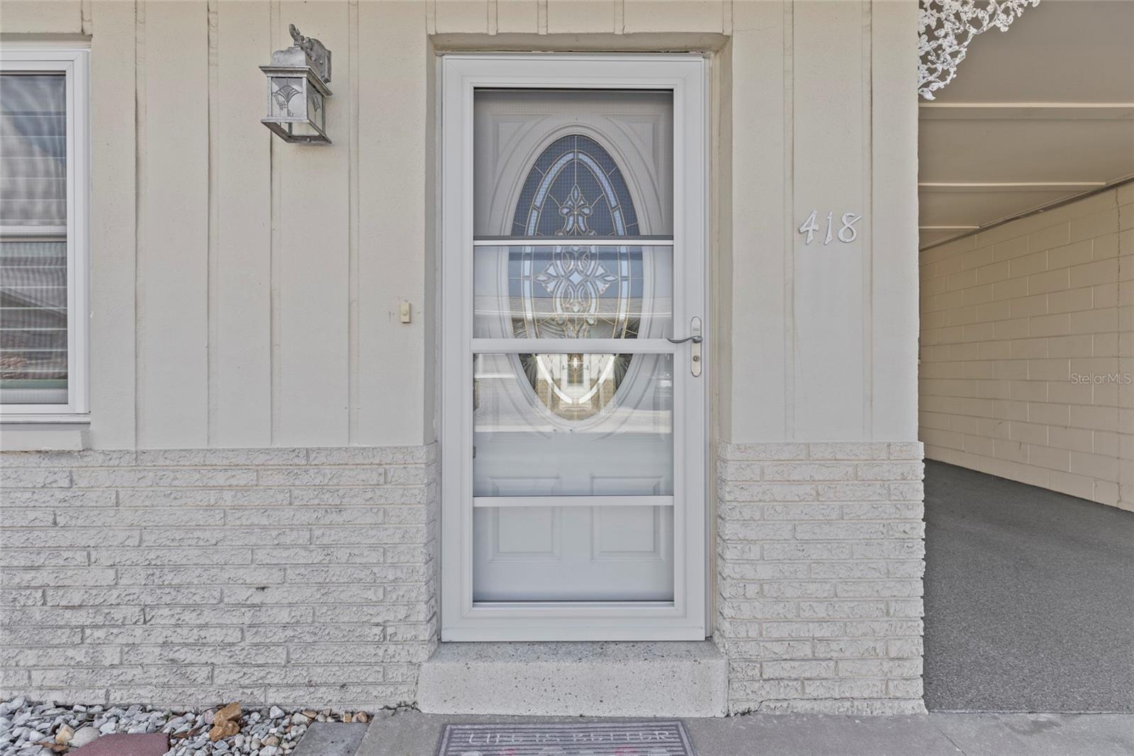 Updated front door with a storm door.