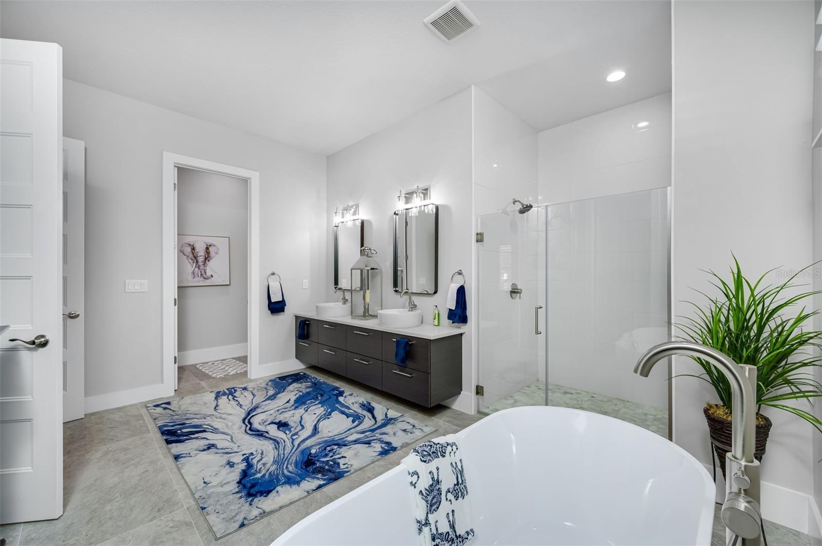 primary bath with separate water closet and floating cabinets