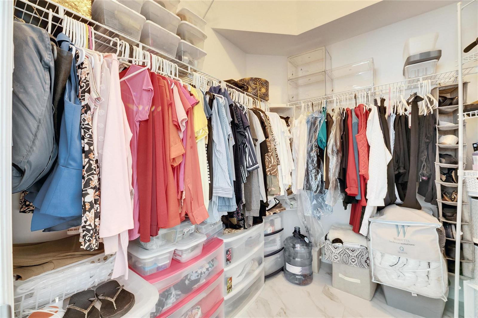Large walk in closet with extra high ceilings and shelving