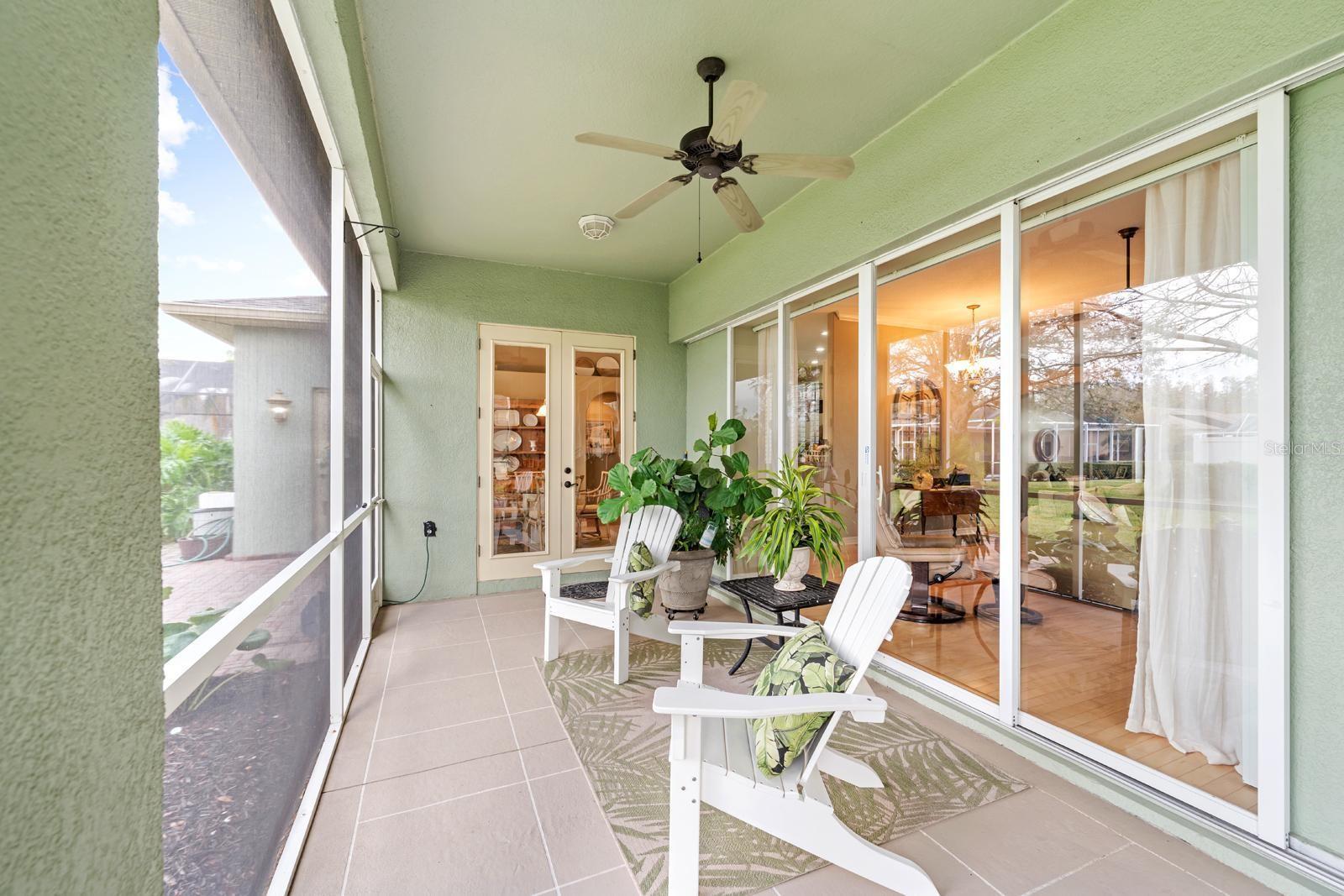 The back patio is a GEM!  It overlooks the beautiful backyard!  It also features two ceiling fans and BRAND NEW screening and NEW screen door hardware....and the 4-panel sliders OPEN UP FULLY!