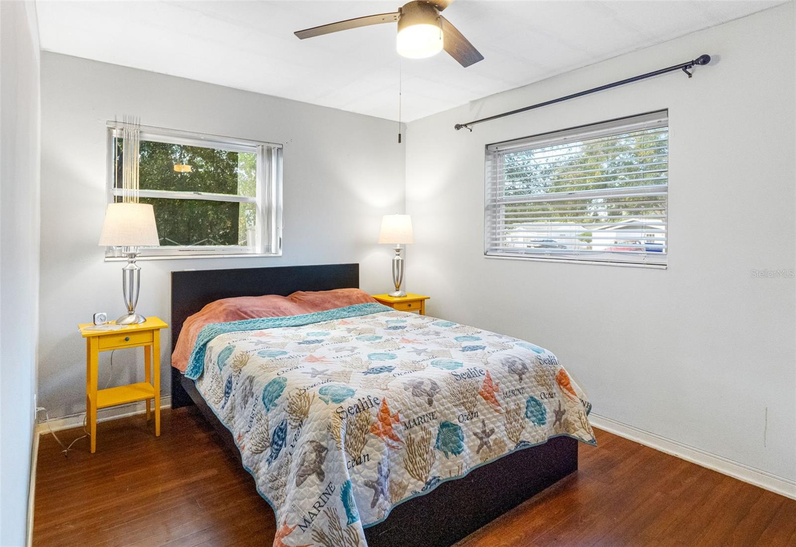 A serene primary bedroom with hardwood floors and plenty of natural light.