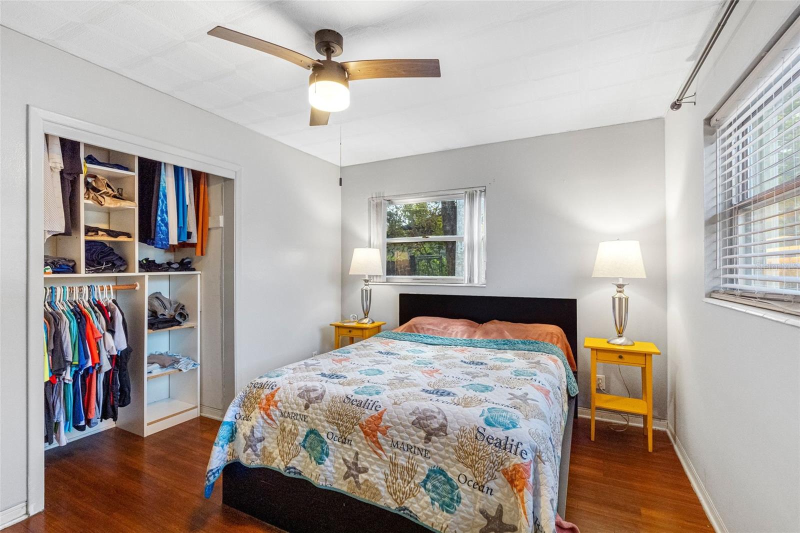 A serene primary bedroom with hardwood floors and plenty of natural light.