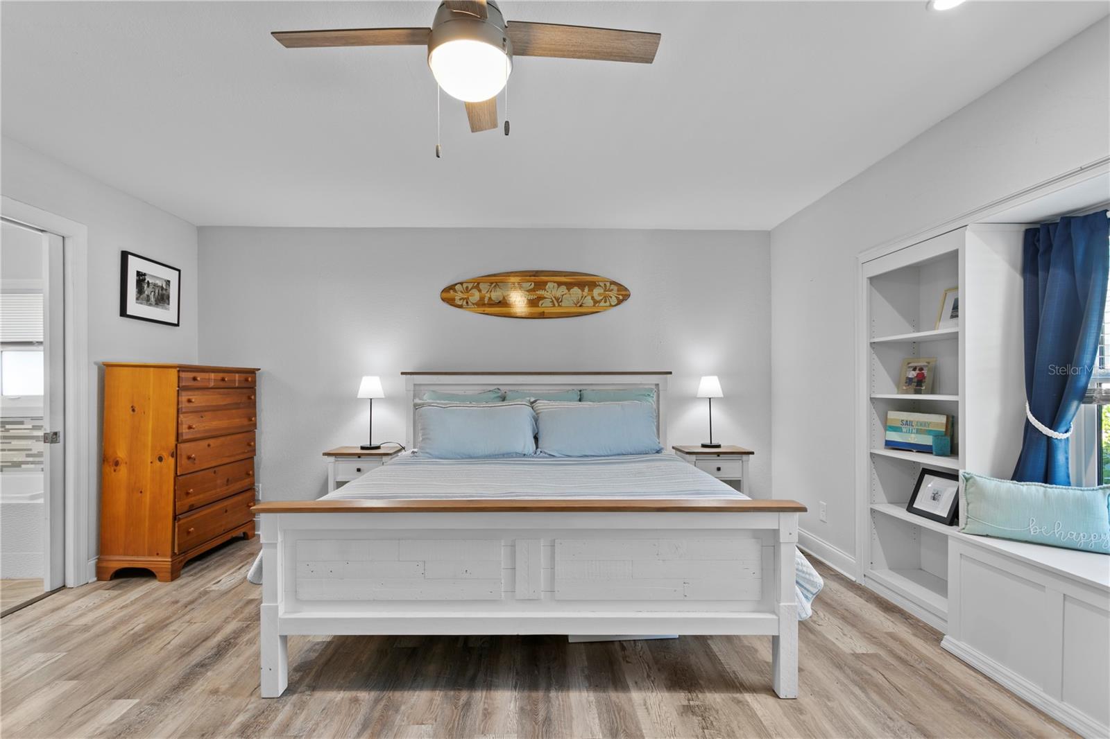 Large primary bedroom with built-in shelves and cabinet