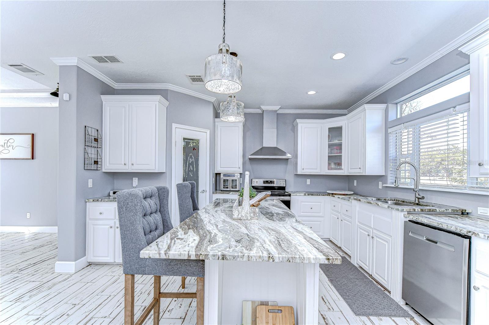 Beautiful kitchen boasting granite countertops, stainless steel appliances, and crown molding.