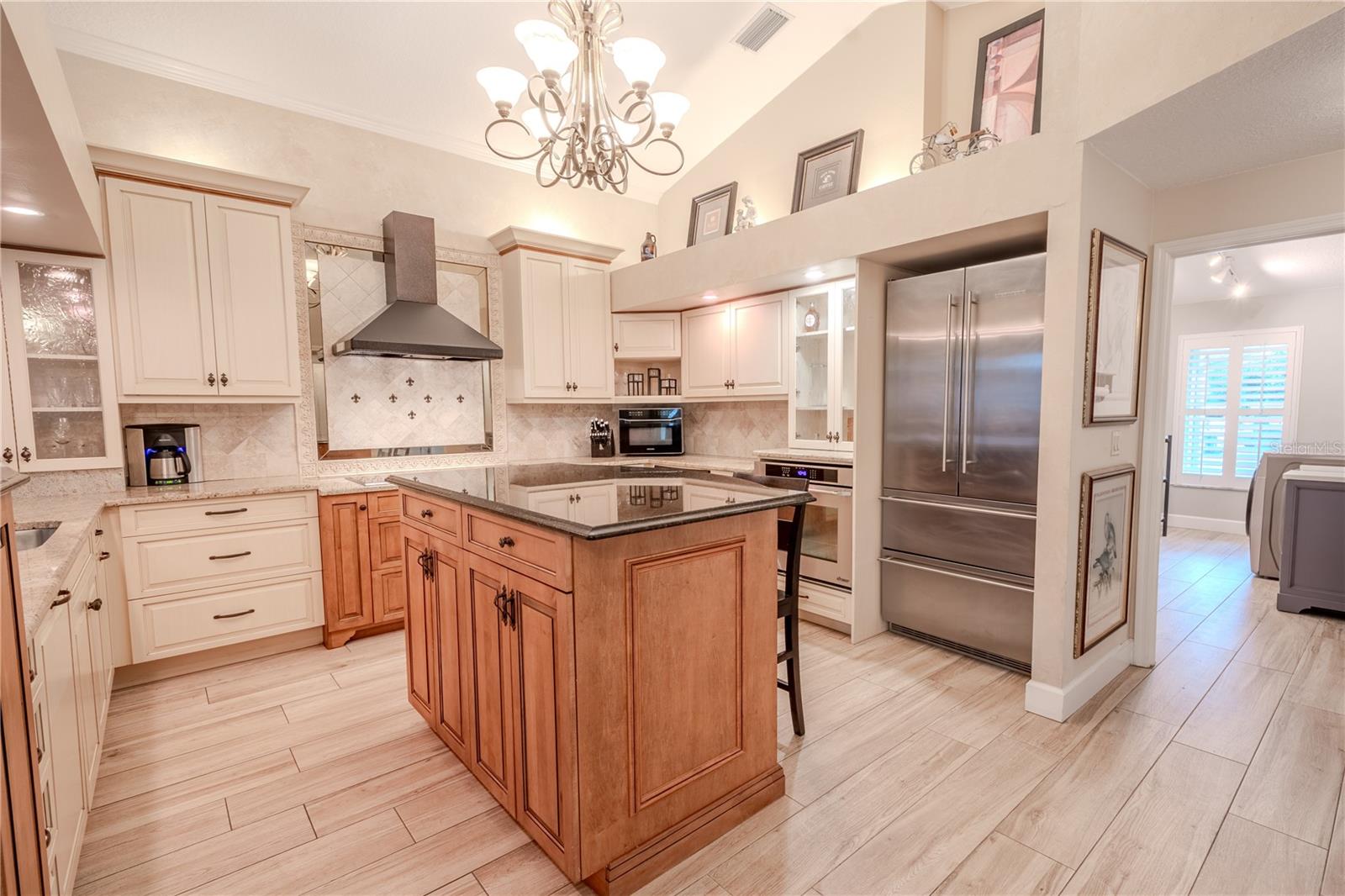 High-end stainless steel appliances include a French door Liebherr refrigerator, Dacor built-in oven, multi-burner Wolf glass cooktop stylish exhaust hood, and a Brew Express plumbed in coffee-maker.