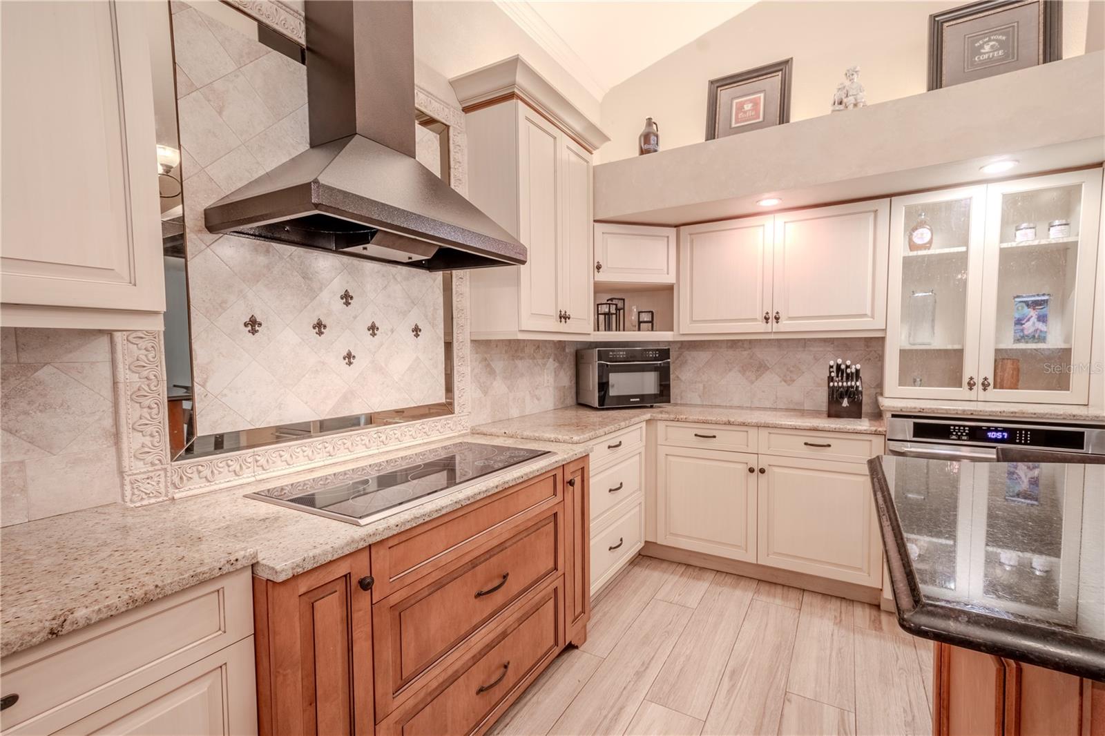 The kitchen features soft-close solid wood cabinets and drawers, granite countertops and a stylish tile backsplash.