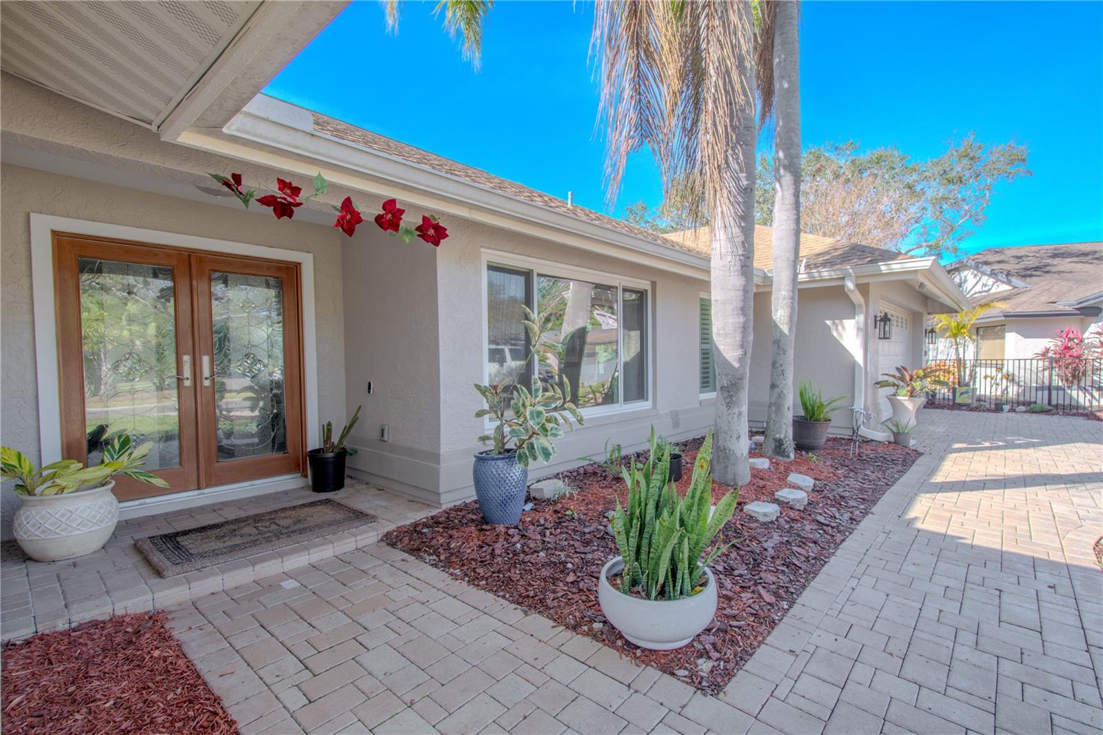 Brick paver drive and walkway, covered entry, double French doors with beveled glass.