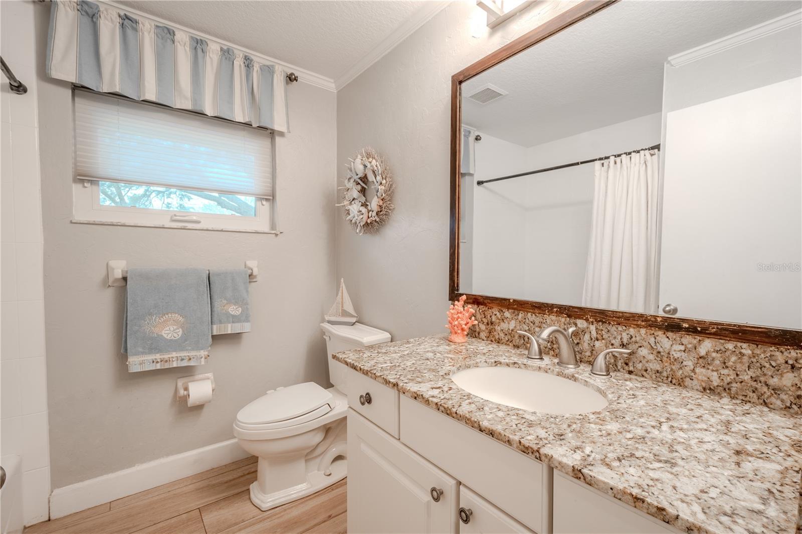 Bathroom 2 features a mirrored vanity with storage and a stone counter, and a tub with shower.