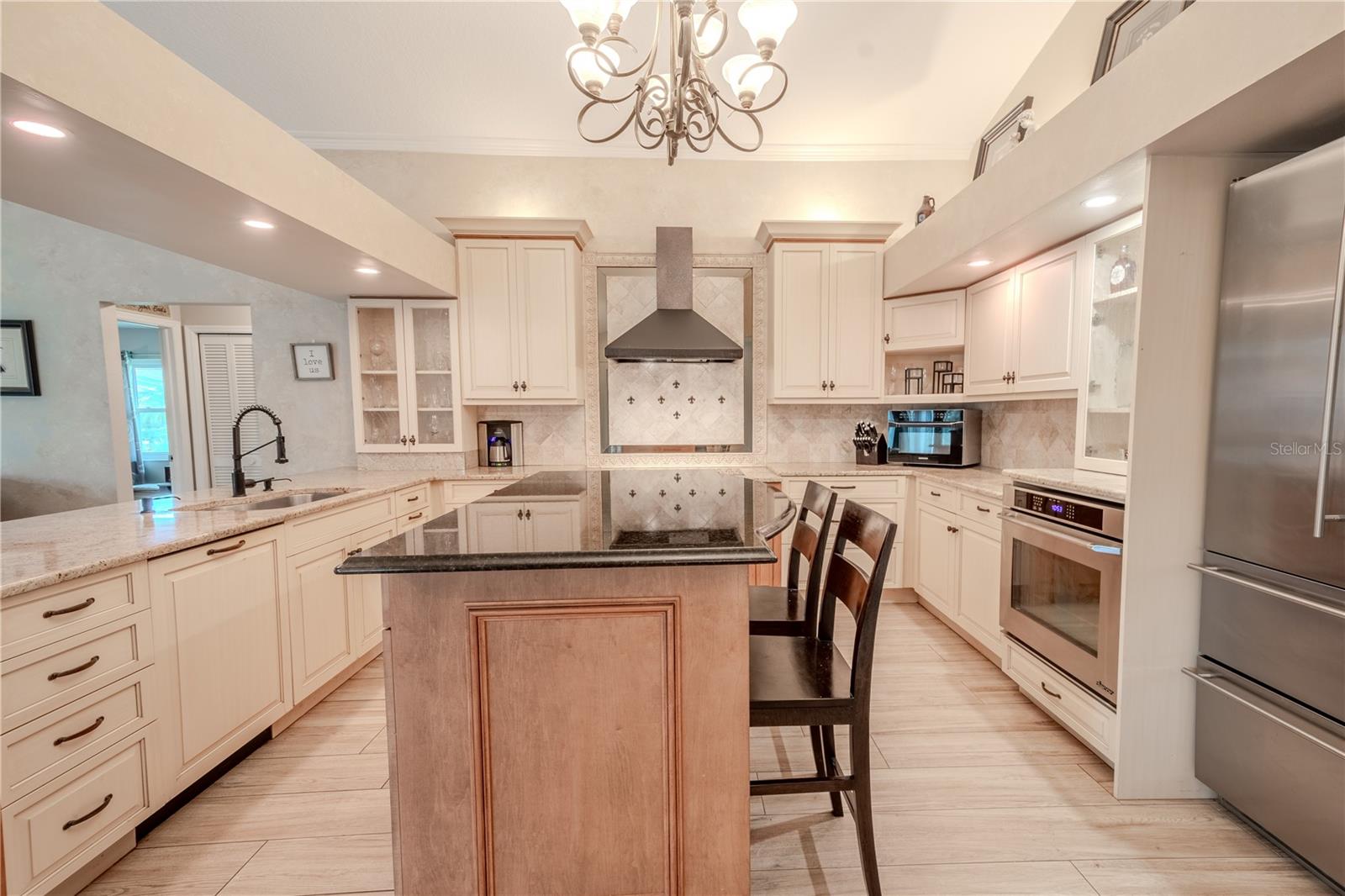 In the center of the kitchen is an solid wood island with a granite countertop, additional storage and seating.