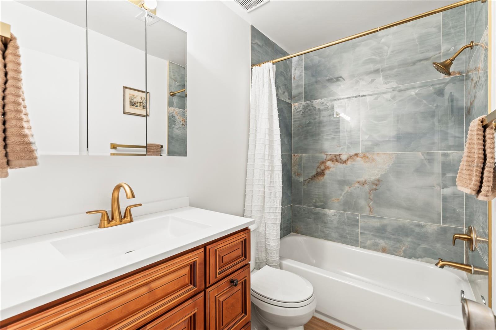 Bathroom closest to the primary bedroom. This bathroom was fully renovated with all new walls, flooring, tile, vanity and fixtures.