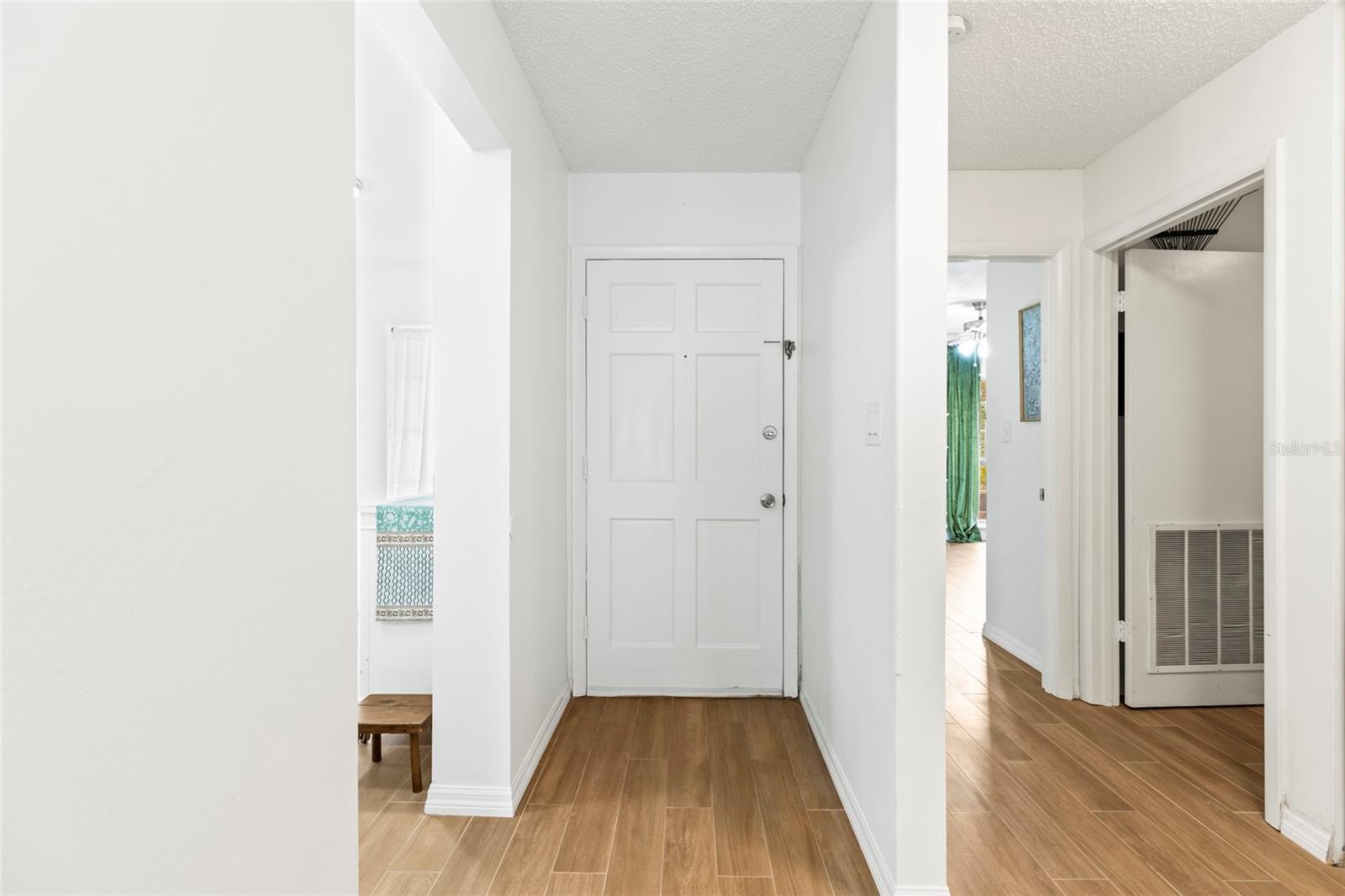 View of the front door. Kitchen to the left, hallway to bedrooms and bathrooms to the right.