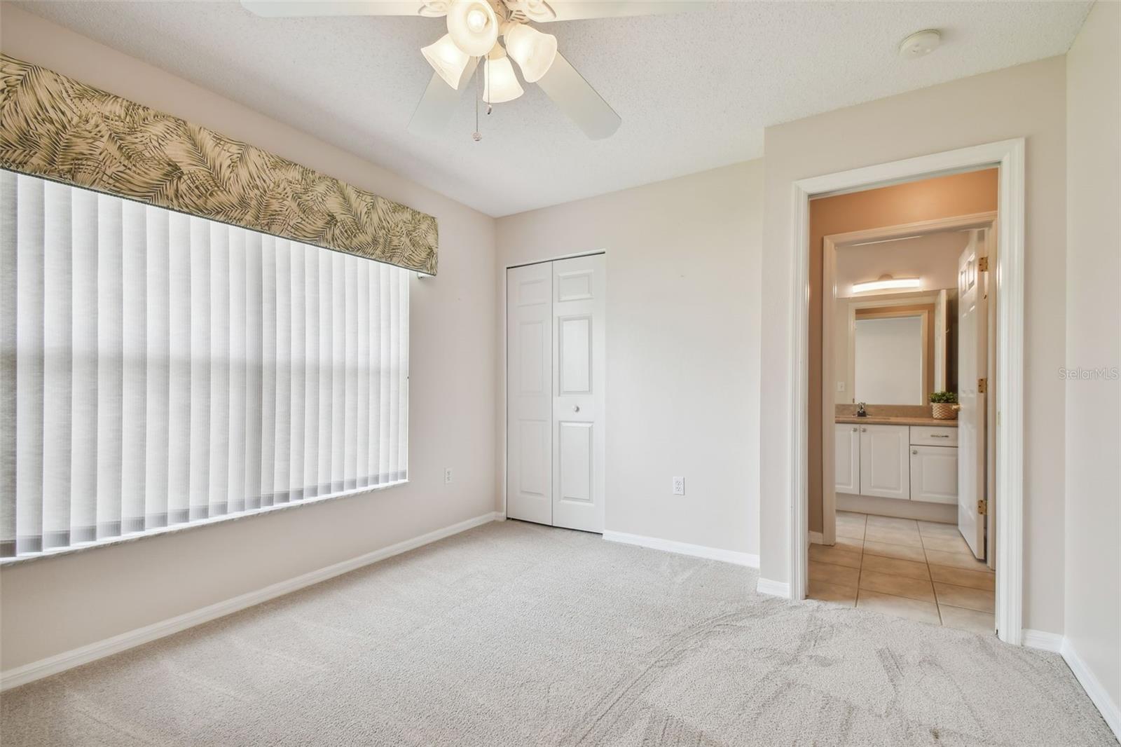 walk in closet with an ensuite hallway bathroom