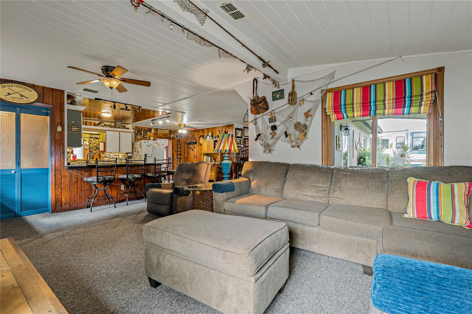 Living Room looking toward Kitchen.  Blue bi-fold doors lead to inside Laundry Room.