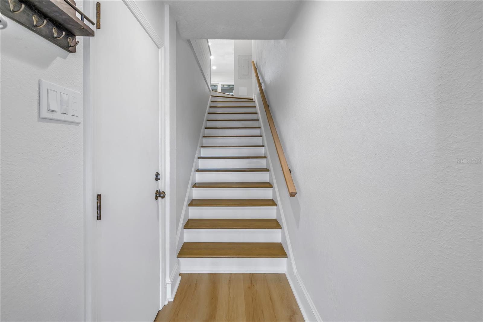 Wood staircase leads to first living level