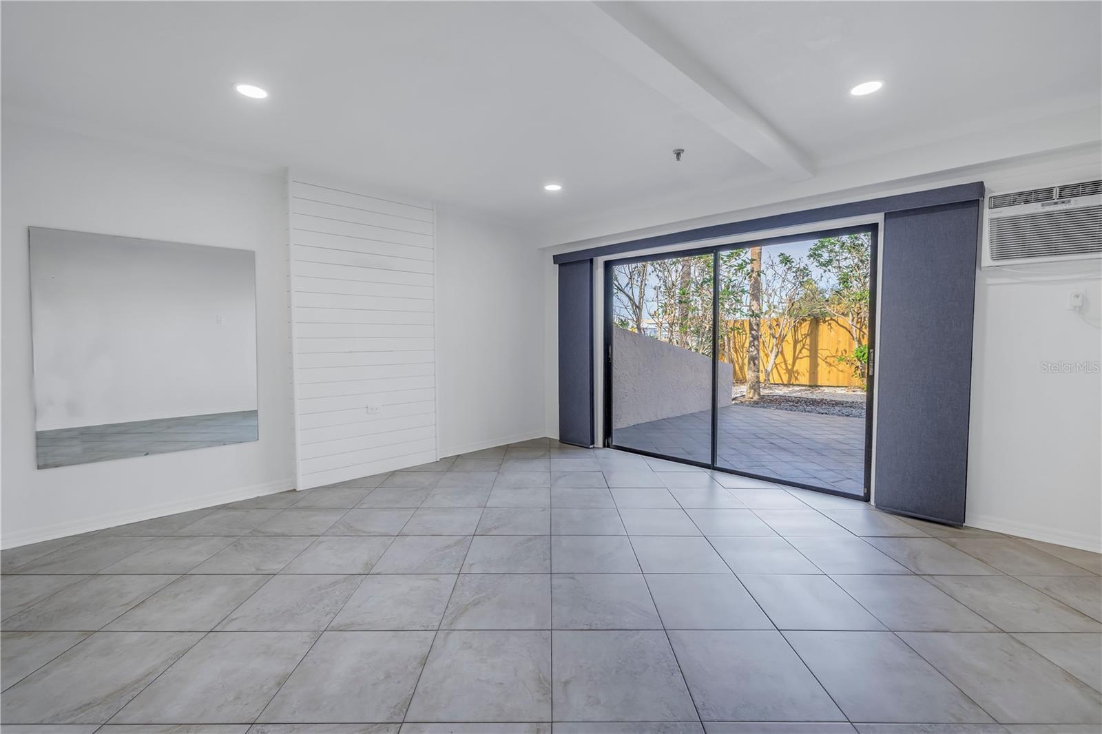 Bonus room behind garage with sliding doors leading to a private patio