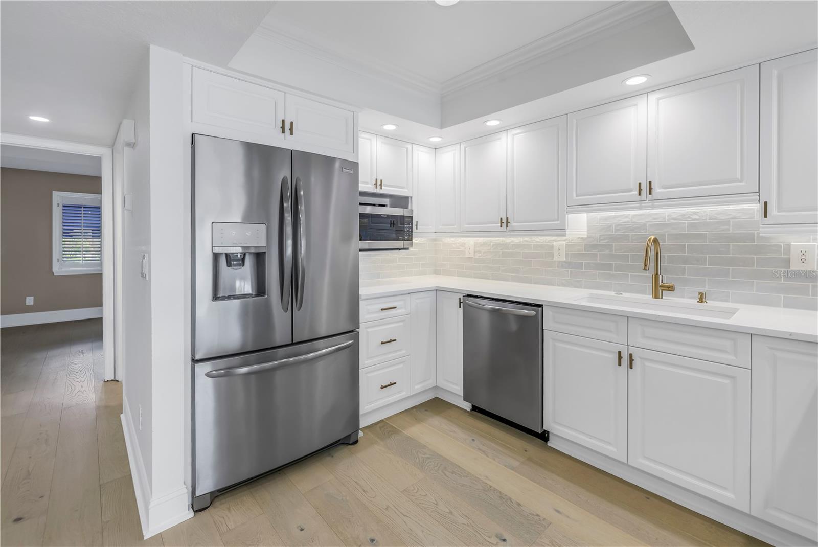 Kitchen with stainless appliances, subway tile backsplash, under cabinet lighting