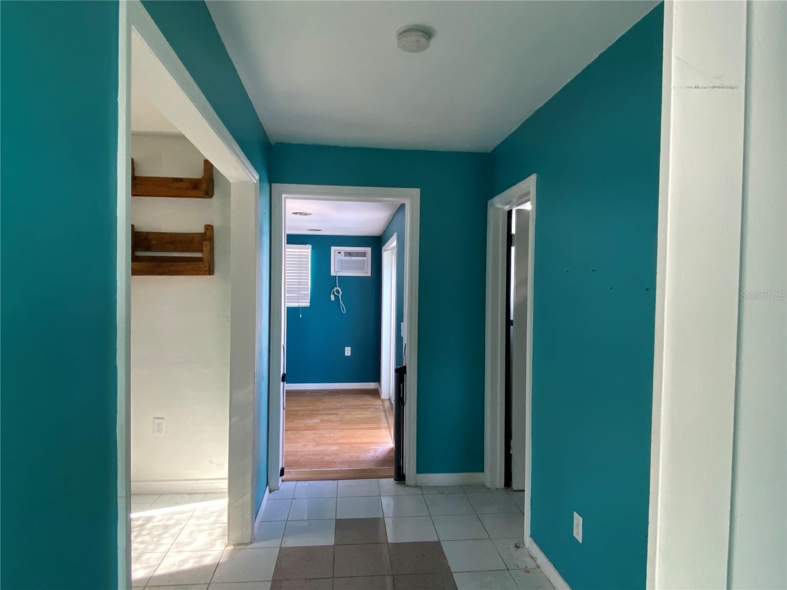 Unit 1 hallway- bonus room to left- closet & bath to right, bedroom directly ahead with sliding door to back yard & pool