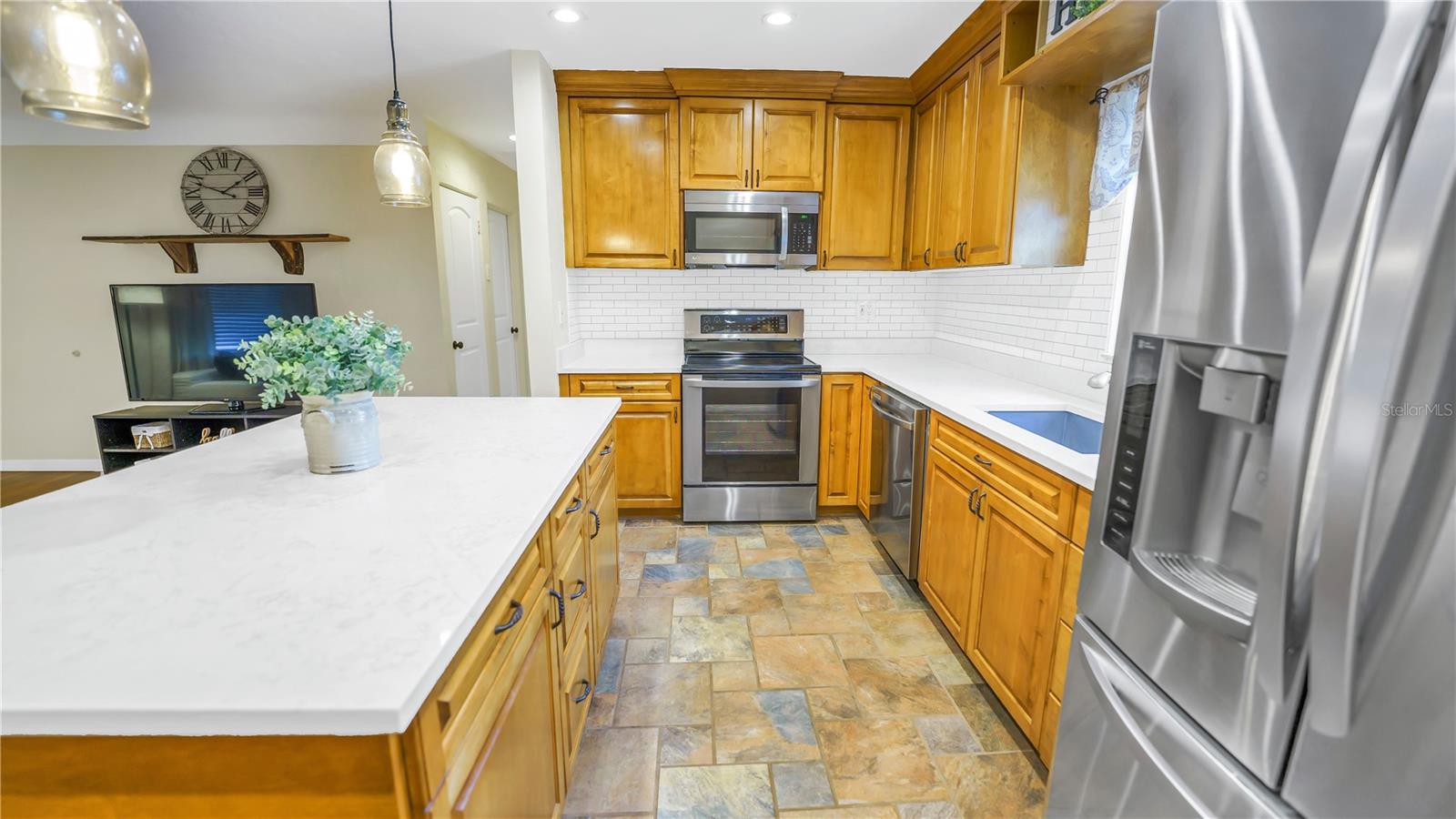 Large island with quartz countertops and stainless appliances