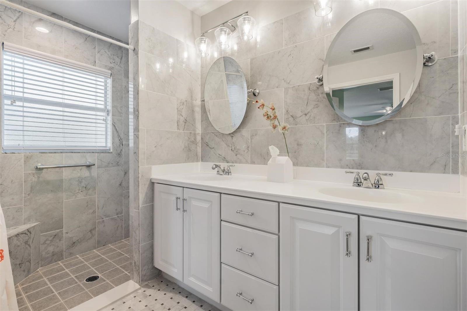 Remodeled and oversized step in shower with double vanity providing additional storage.