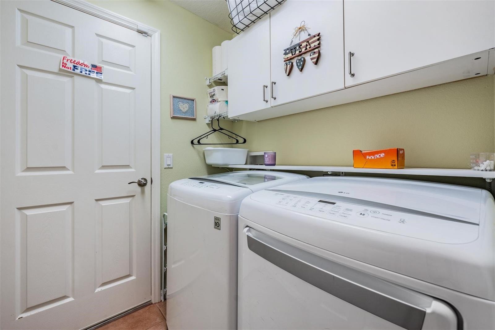 Walk-in laundry room with built-in cabinets