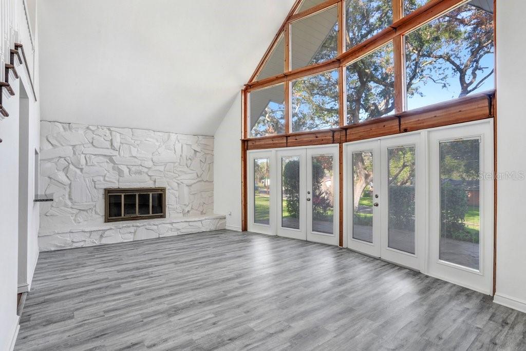 Living Room with pass through to kitchen, staircase to primary suite and wood burning fireplace.