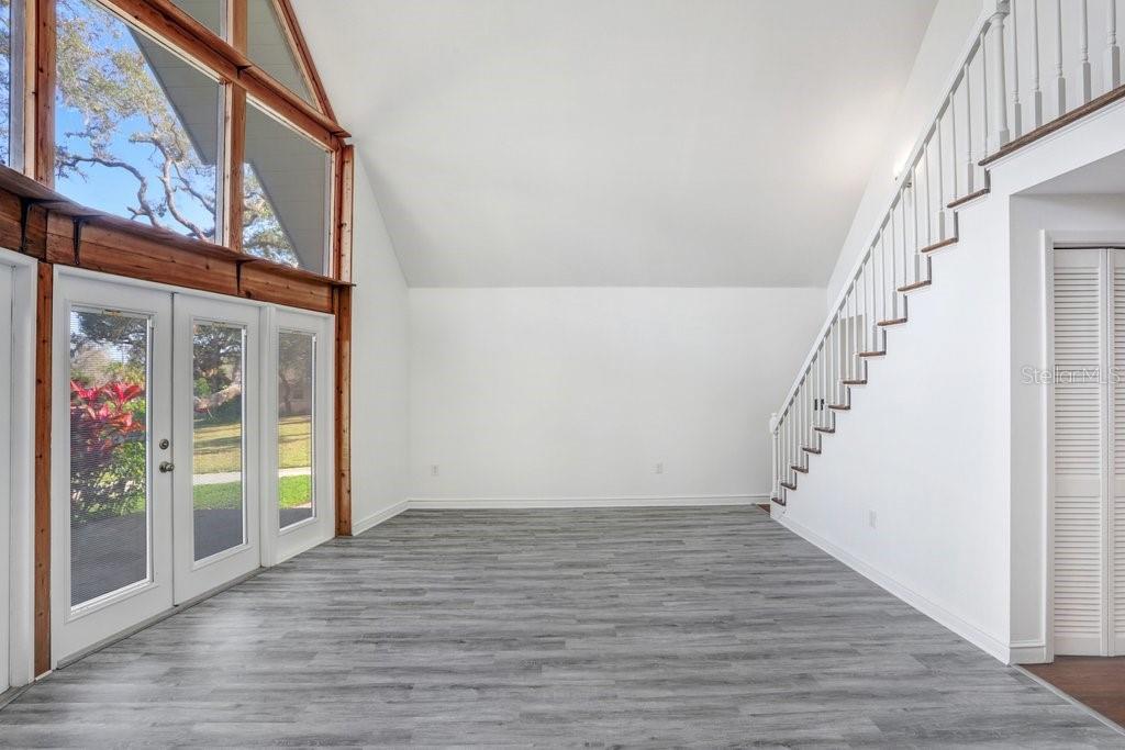 Living Room with pass through to kitchen, staircase to primary suite and wood burning fireplace.