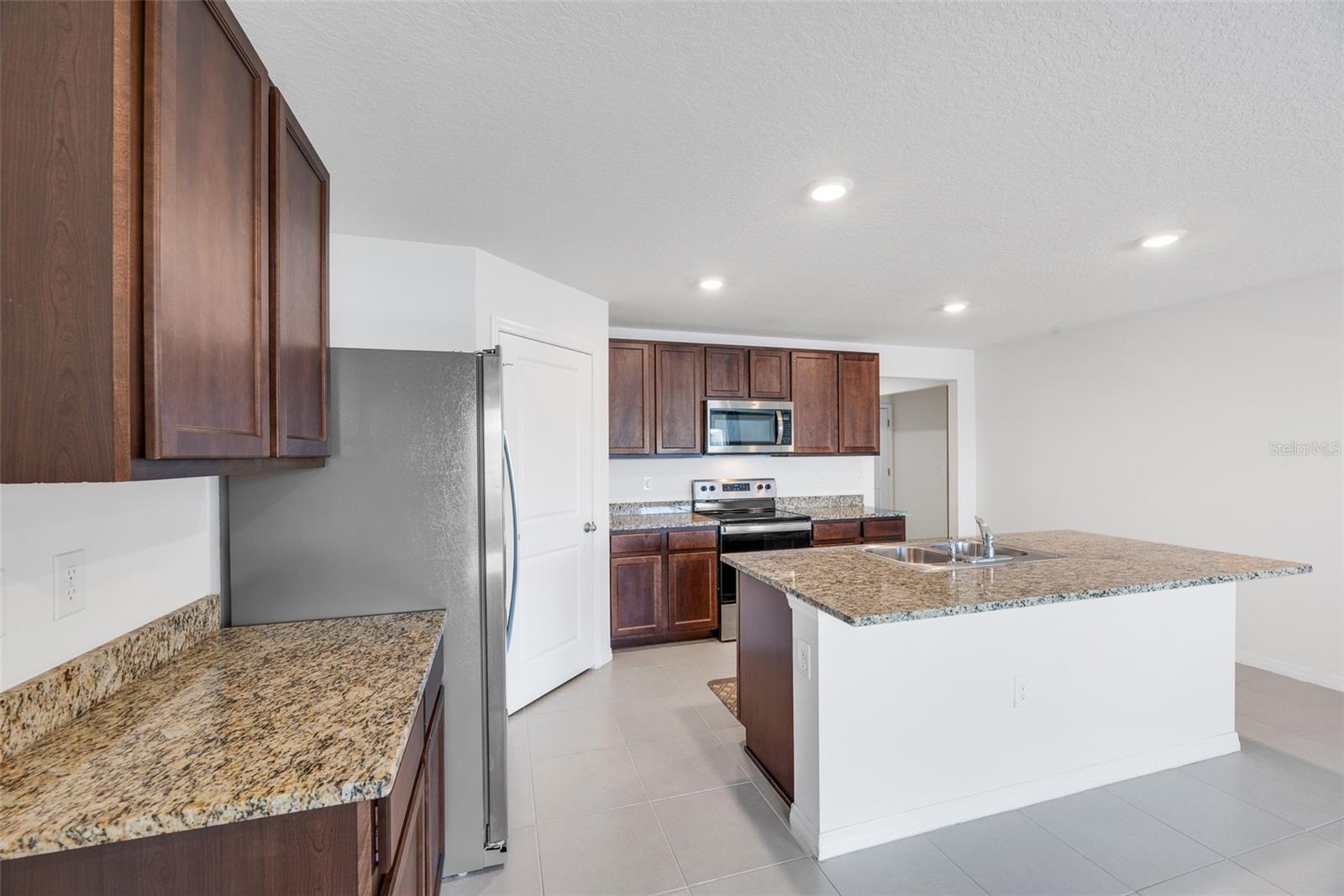 Kitchen island with sink has room for additional seating making entertaining a breeze.