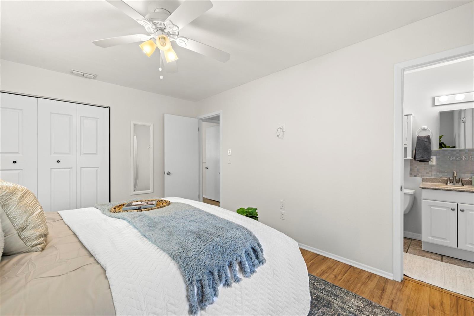 Primary bedroom with en-suite, with door to screened in patio & pool