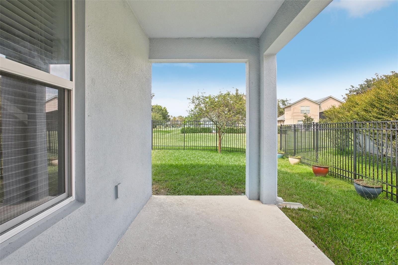 Rear patio area with fenced in backyard