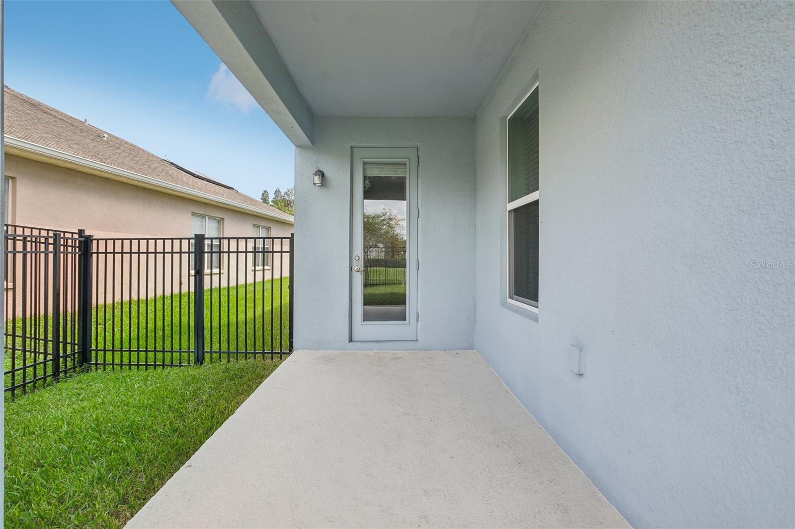 Rear patio area with fenced in backyard