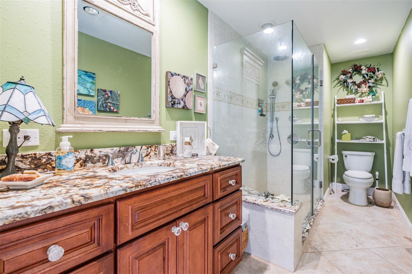 Guest Bathroom, Granite counter top, Seamless door shower and tile flooring.