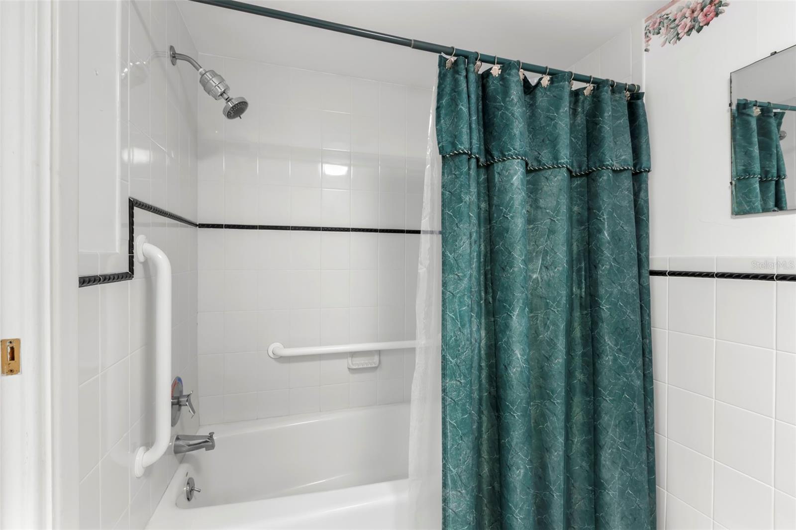 Primary bathroom has a tub/shower combo with shower seat.