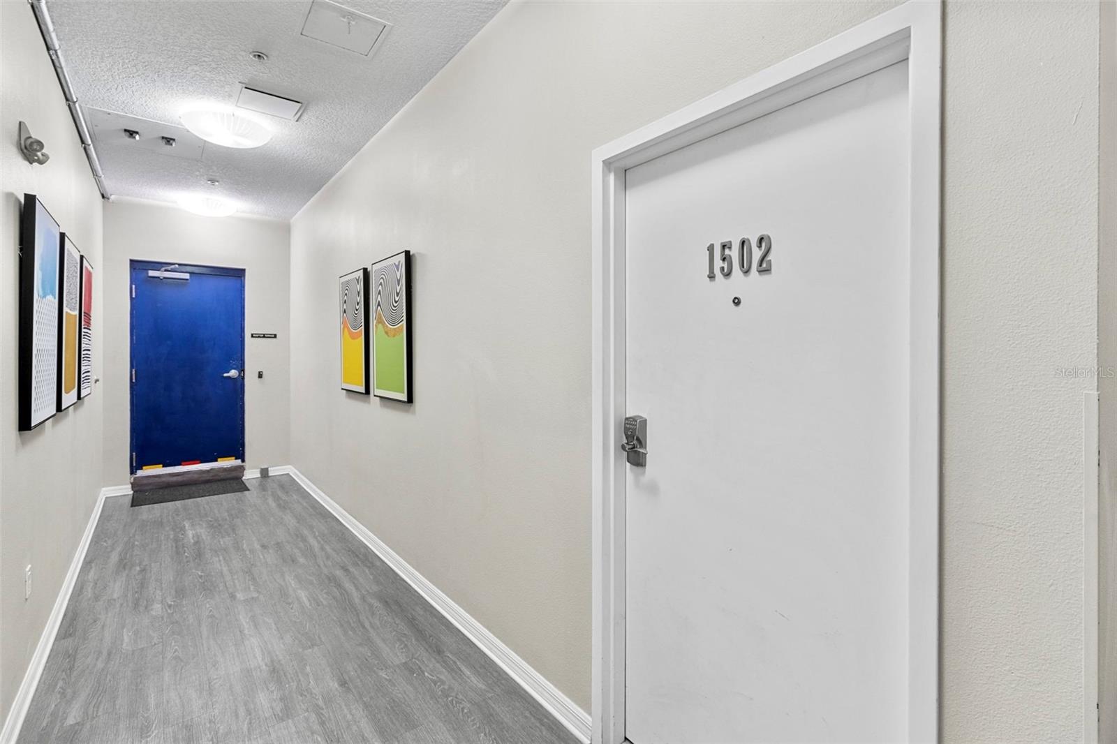 15th Floor hallway with blue door to the Community Rooftop Terrace just steps beyond the from entry to #1502. Only 2 condo's are on the 15th floor.