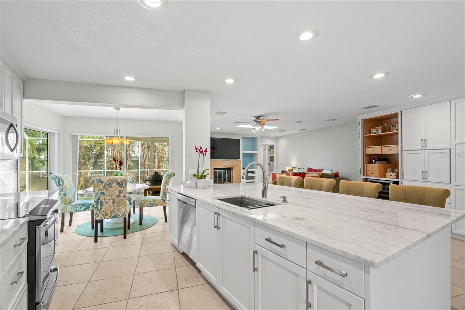 The kitchen features stunning marble countertops, shaker-style extended wood cabinetry, a large island and breakfast bar.