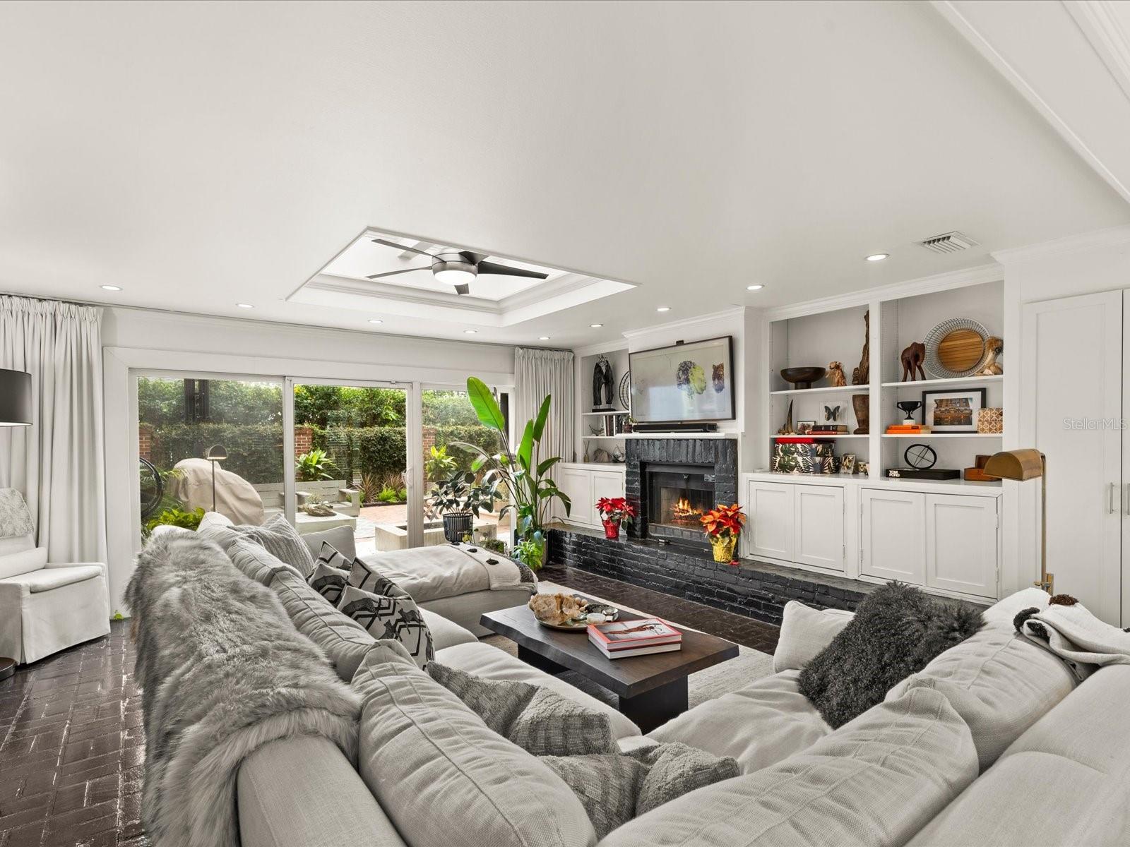 Sunken Family room with Fireplace and entrance to outdoor living space.