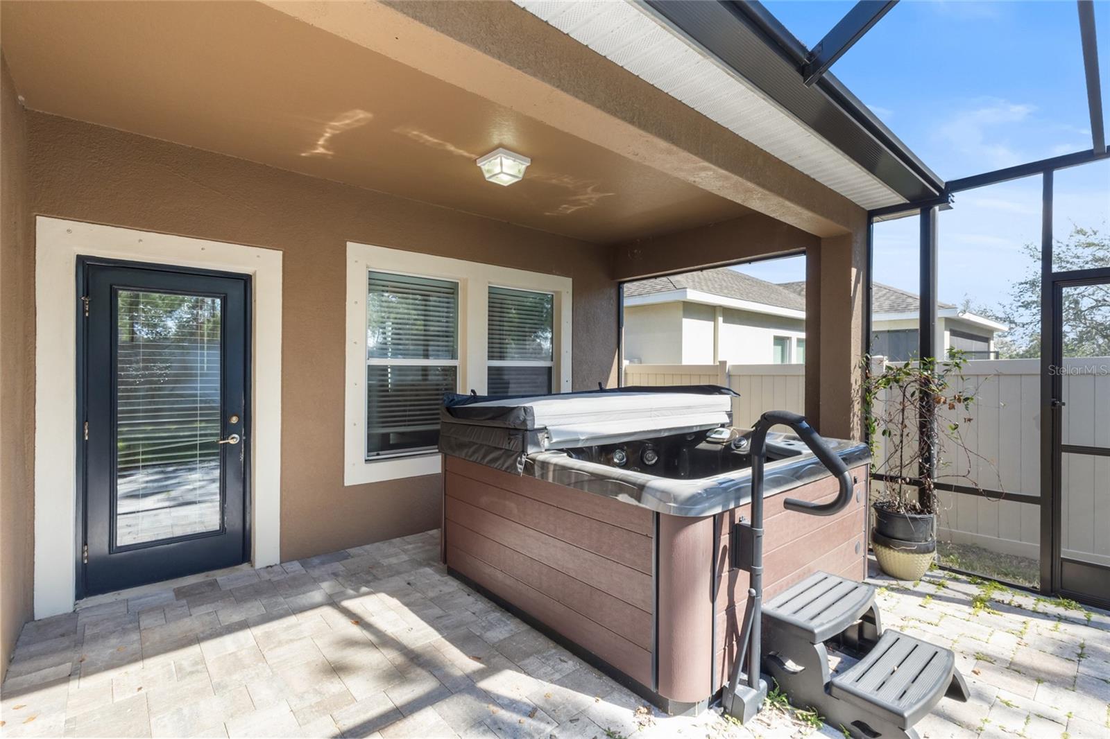 Screened patio with a hot tub